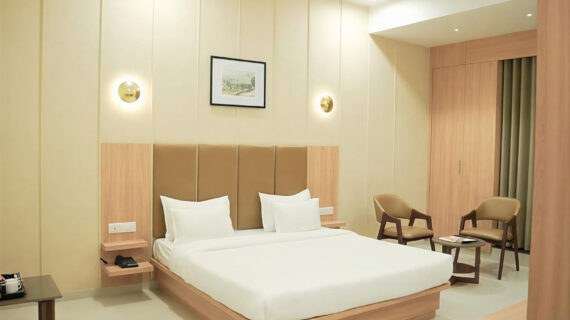 Double bed room with king-sized bed and beige panelled headboard at Maharashtra Bhuvan, Palitana